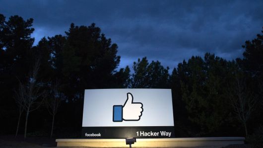 A lit sign is seen at the entrance to Facebook's corporate headquarters location in Menlo Park, California on March 21, 2018. 
