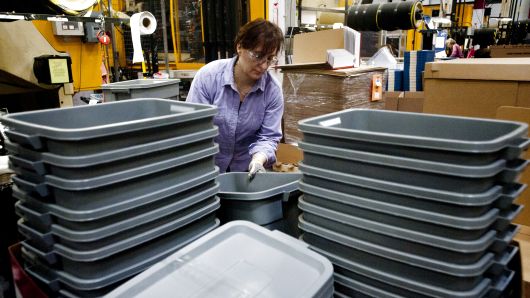 An employee stacks containers as they come out of the molding machine at the Newell Rubbermaid factory in Mogadore, Ohio