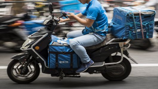 A driver for Ele.me, Alibaba Group Holding Ltd.'s food-delivery platform, rides a motorcycle along a road in Shanghai, China, on Monday, Aug. 20, 2018. 
