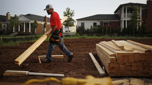 A contractor moves lumber for a house under construction in the Norton Commons subdivision of Louisville, Kentucky.