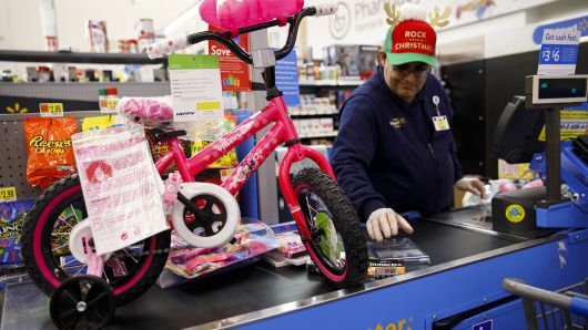 An employee prepares to scan a children's bicycle for a customer at a Wal-Mart Stores Inc. location in Burbank, California, U.S., on Thursday, Nov. 16, 2017.