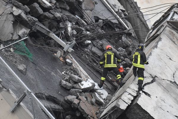 Rescuers at work amid the rubble after a highway bridge collapsed in Genoa, Italy, 14 August 2018. A large section of the Morandi viaduct upon which the A10 motorway runs collapsed in Genoa on Tuesday. 