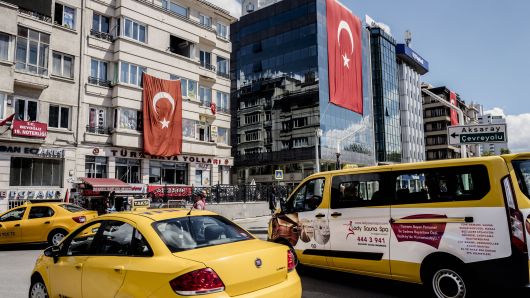 Yellow cabs sit at a taxi rank near buildings decorated with Turkish national flags in Istanbul, Turkey, on Tuesday, July 19, 2016. 
