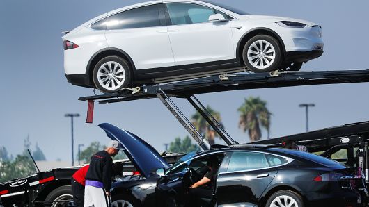 Newly manufactured Tesla vehicles are placed on transport trailers from a large inventory of newly made vehicles in Burbank, California, August 24, 2018. 