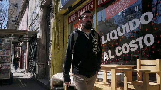 A man walks past a store selling off in Buenos Aires, on September 4, 2018. 