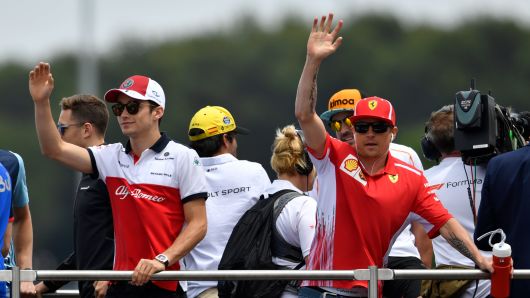 Ferrari's Finnish driver Kimi Raikkonen (R) and Sauber F1's Monegasque driver Charles Leclerc (L) wave from a truck during a parade ahead of the Formula One Grand Prix de France at the Circuit Paul Ricard in Le Castellet, southern France, on June 24, 2018.