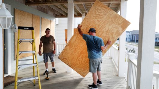 Workers prepare a house with storm shutters ahead of the arrival of Hurricane Florence in Ocean Isle Beach, North Carolina, September 12, 2018. 