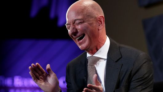 Jeff Bezos, president and CEO of Amazon and owner of The Washington Post, laughs during an interview at the Economic Club of Washington DC's "Milestone Celebration Dinner" in Washington, U.S., September 13, 2018. 