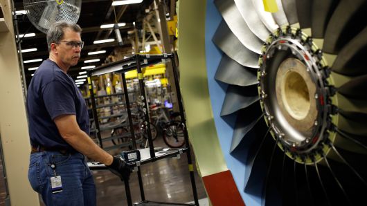 A production assembly mechanic prepares to install a bracket on a CFM56-7 jet engine at General Electric Co.'s GE Aviation factory in Cincinnati, Ohio, June 25, 2014.