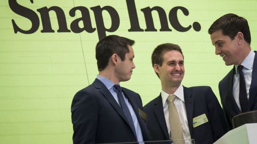Snapchat co-founders Bobby Murphy (l) and Evan Spiegel (c) ring the opening bell on March 2, 2017, as NYSE President Thomas Farley looks on.