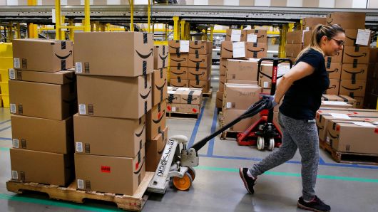 An employee pulls a cart stacked with boxes at the Amazon.com fulfillment center in Kenosha, Wisconsin.