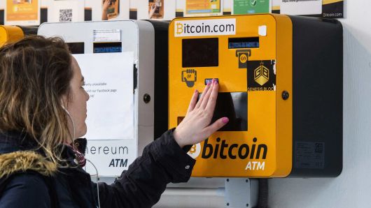 A woman touches an ATM machine for digital currency Bitcoin in Hong Kong on December 18, 2017.