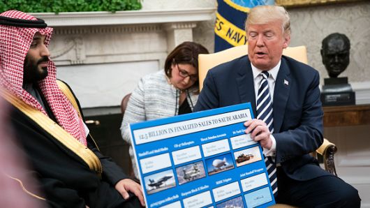 President Donald Trump shows off posters as he talks with Crown Prince Mohammad bin Salman of the Kingdom of Saudi Arabia during a meeting in the Oval Office at the White House on Tuesday, March 20, 2018 in Washington, DC. 