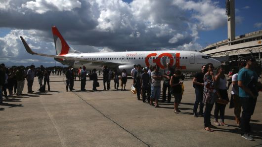 Attendees stand in line in front of a Boeing Co. aircraft operated by GOL Airlines SA during the International Brazil Air Show (IBAS) at Rio Galeao International Airport in Rio de Janeiro, Brazil, on Saturday, April 1, 2017. 