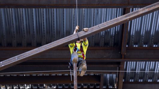 A contractor guides a steel beam into place while working on the Korean Air Lines Co. Wilshire Grand hotel and office building in downtown Los Angeles, California.