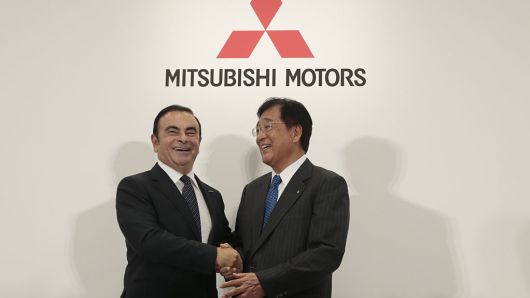 Carlos Ghosn, chairman and chief executive officer of Renault and Nissan Motor, left, shakes hands with Osamu Masuko, chairman and chief executive officer of Mitsubishi Motors, at a news conference in Tokyo, on Thursday, Oct. 20, 2016.