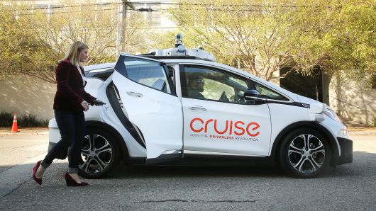 A woman gets in a self-driving Chevy Bolt EV car during a media event by Cruise, GM’s autonomous car unit, in San Francisco, California, November 28, 2017.