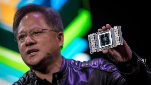 Jen-Hsun Huang, president and chief executive officer of Nvidia Corp., holds a Nvidia Volta 125 Teraflops per second (TFLOPS) Tensor Core as he speaks during an event at the 2018 Consumer Electronics Show (CES) in Las Vegas, Nevada, U.S., on Sunday, Jan. 7, 2018.