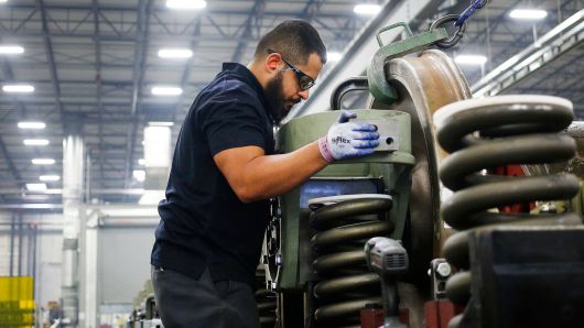 An employee helps install a traction motor onto the truck of a General Electric Evolution Series Tier 4 diesel locomotive at the GE Manufacturing Solutions facility in Fort Worth, Texas.