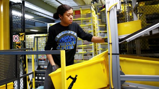 An employee works on picking order items from inventory shelves at the Amazon fulfillment center in Kent, Washington, October 24, 2018.