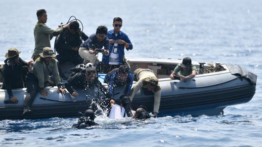 Indonesian Navy divers try to put a 'black box' into a plastic container after its discovery during search operations for the ill-fated Lion Air flight JT 610 at sea, north of Karawang in West Java on November 1, 2018.