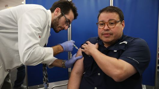 Mario Ancalmo receives an influenza vaccination from Raphael Lynne, Pharm. D., MBA, at the CVS/pharmacy on October 4, 2018 in Miami, Florida. 