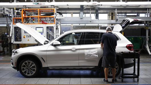 A worker applies final touches on a Bayerische Motoren Werke AG (BMW) sports utility vehicle (SUV) on an assembly line at the BMW Manufacturing Co. plant in Greer, South Carolina, U.S. on Thursday, May 10, 2018. 
