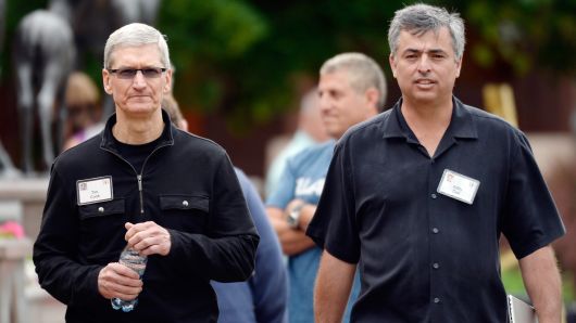 CEO Tim Cook (L) and senior vice president of Internet Software and Services Eddy Cue of Apple speak as they walk after lunch during the Allen & Co. annual conference at the Sun Valley Resort on July 11, 2013 in Sun Valley, Idaho.
