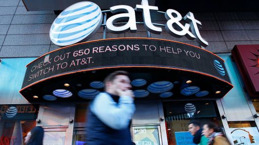 People walk past an AT&T store in New York on October 23, 2016.