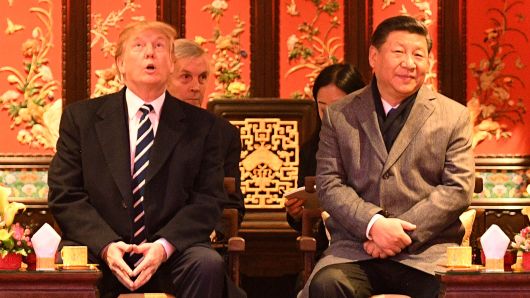 US President Donald Trump (L) looks up as he sits beside China's President Xi Jinping (R) during a tour of the Forbidden City in Beijing on November 8, 2017.