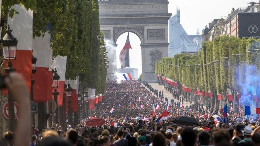 French fans attend the French football team parade on the Champs Elysees in a double-decker bus the day after their victory in the 2018 World Cup final, on July 16, 2018 in Paris, France. The French team won their second star after winning 4-2 against Croatia in the final.