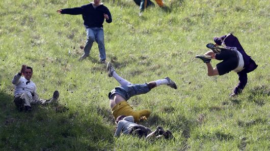 Contestants in the men's race chase a Double Gloucester Cheese down the steep gradient of Cooper's Hill during the annual tradition of cheese-rolling in Brockworth, Gloucestershire, England.
