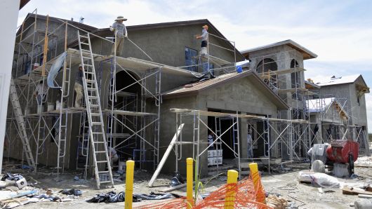 A stucco crew plasters the exterior of a new two-story home at the Lennar Corp. Madison Pointe at Central Park development in Doral, Florida.