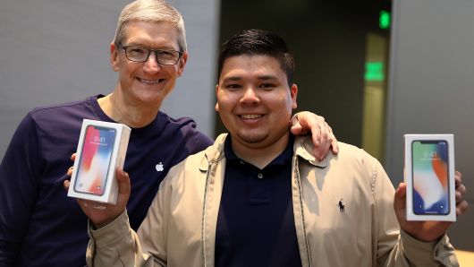 Apple CEO Tim Cook (L) takes a picture with David Casarez (R) who just purchased the new iPhone X at an Apple Store on November 3, 2017 in Palo Alto, California.