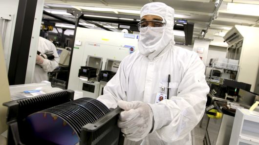 Robert Neely prepares to load a silicon wafer machine in a clean room at the Texas Instruments semiconductor fabrication plant in Dallas, Texas, U.S., on Tuesday, June 16, 2009. Texas Instruments Inc., the second-largest U.S. semiconductor maker, reported sales and profit that beat analysts' estimates on stronger demand for chips used in mobile phones and communications networks in China.  (Photo by Jason Janik/Bloomberg via Getty Images)