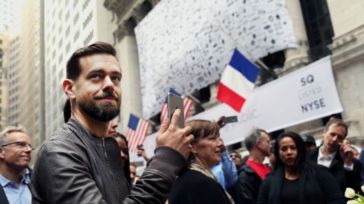 Jack Dorsey, CEO of Square Inc., holds an Apple Inc. iPhone while standing outside of the New York Stock Exchange (NYSE) in New York, U.S., on Thursday, Nov. 19, 2015.