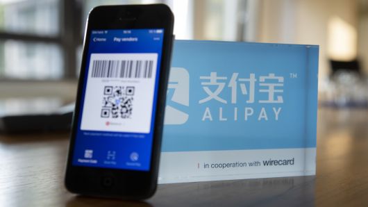 An Alipay digital payment app logo and smartphone sit on a desktop at the Wirecard AG headquarters in Munich, Germany, on Wednesday, Sept. 5, 2018.