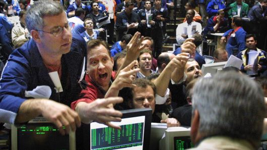 Traders in the OEX pit at the Chicago Board Options Exchange climb the walls of the pit in their scramble to make trades 18 April 2001 in Chicago, Illinois, at the moment news hits that the Federal Reserve has made an unexpected half-point cut in interest rates.   A