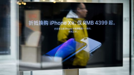 A man is reflected on a screen showing the iPhone XR at an Apple store in Beijing on January 3, 2019.