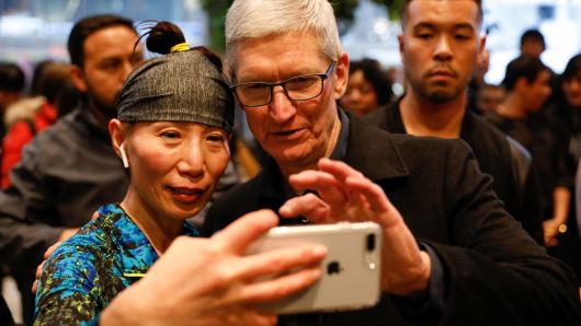 Tim Cook, Chief Executive Officer of Apple Inc., takes a selfie with a customer and her iPhone as he visits the Apple Store in Chicago, Illinois, U.S., March 27, 2018.
