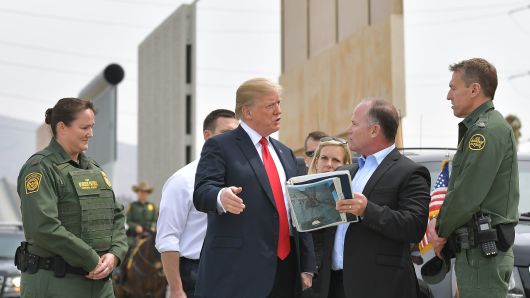President Donald Trump (C) is shown border wall prototypes in San Diego, California on March 13, 2018.