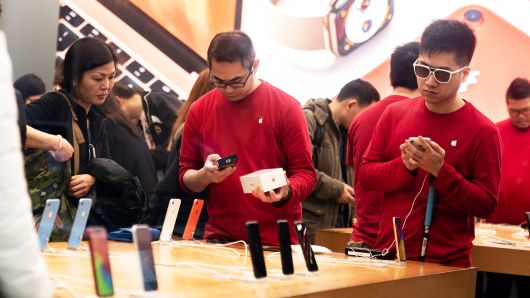 Employees serve customers inside an Apple store in Hong Kong, China, on Thursday, Jan. 3, 2019.