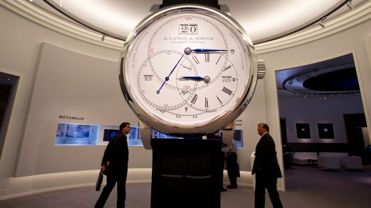 Visitors pass a giant model of a luxury A. Lange & Soehne wristwatch, manufactured by Lange Uhren GmbH, a watchmaking unit of Cie. Financiere Richemont SA.