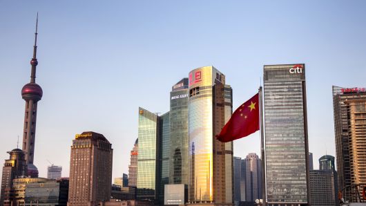 SHANGHAI, CHINA - FEBRUARY 23: The Chinese flag floats before the skyscrapers of multinational corporations on February 23, 2018 in Shanghai, China.