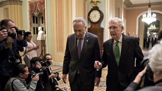 Senate Majority Leader Mitch McConnell, a Republican from Kentucky, right, talks to Senate Minority Leader Chuck Schumer, a Democrat from New York, while walking towards the Senate Chamber at the U.S. Capitol in Washington, D.C., U.S., on Wednesday, Feb. 7, 2018.