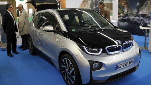 Visitors look at a BMW i3 electric automobile during the Paris Motor Show on October 14, 2014 in Paris, France