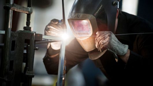 An employee welds a specialized metal product in the shop at the Amuneal Manufacturing plant in Philadelphia, Pennsylvania.