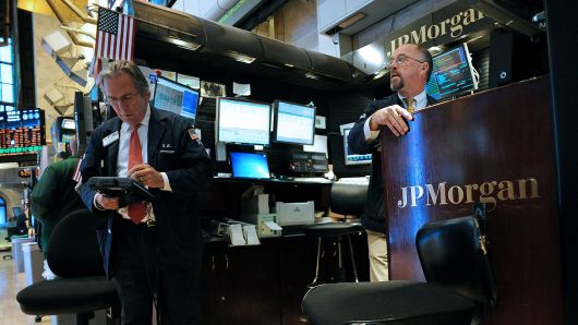 Traders work at the JPMorgan Chase & Co. booth on the floor of the New York Stock Exchange (NYSE) in New York.