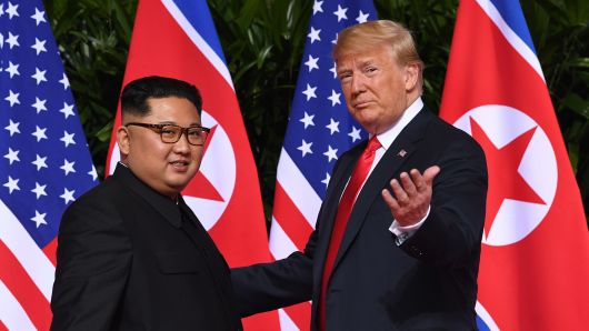 President Donald Trump (R) gestures as he meets with North Korea's leader Kim Jong Un (L) at the start of their historic US-North Korea summit, at the Capella Hotel on Sentosa island in Singapore on June 12, 2018.