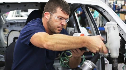 An employee installs interior accessories inside a BMW X4 sports utility vehicle on the assembly line at the BMW assembly plant in Greer, South Carolina.